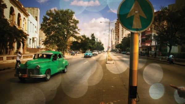 Location shot of Havana street with green vintage car in the foreground